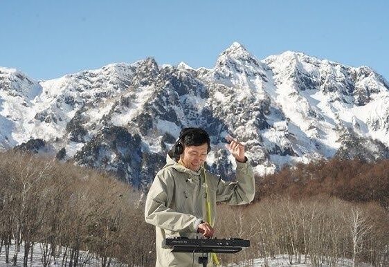 DJ mixant sur un contrôleur dans un paysage montagneux enneigé