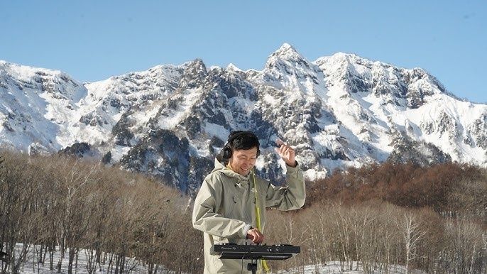 DJ mixant sur un contrôleur dans un paysage montagneux enneigé